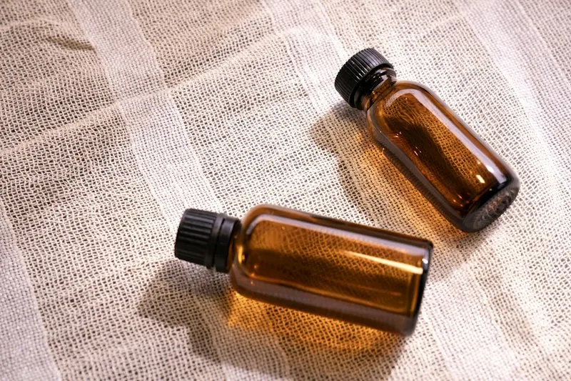 白い布の上に置かれた茶色の小瓶