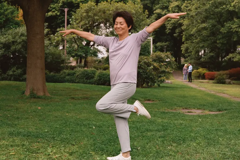 朝の公園で片足立ちをする60代の女性